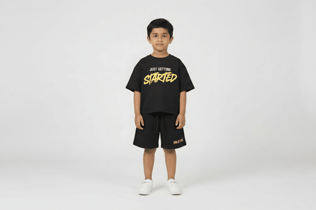 Child wearing a black t-shirt with 'Just Getting Started' text and black shorts on a white background