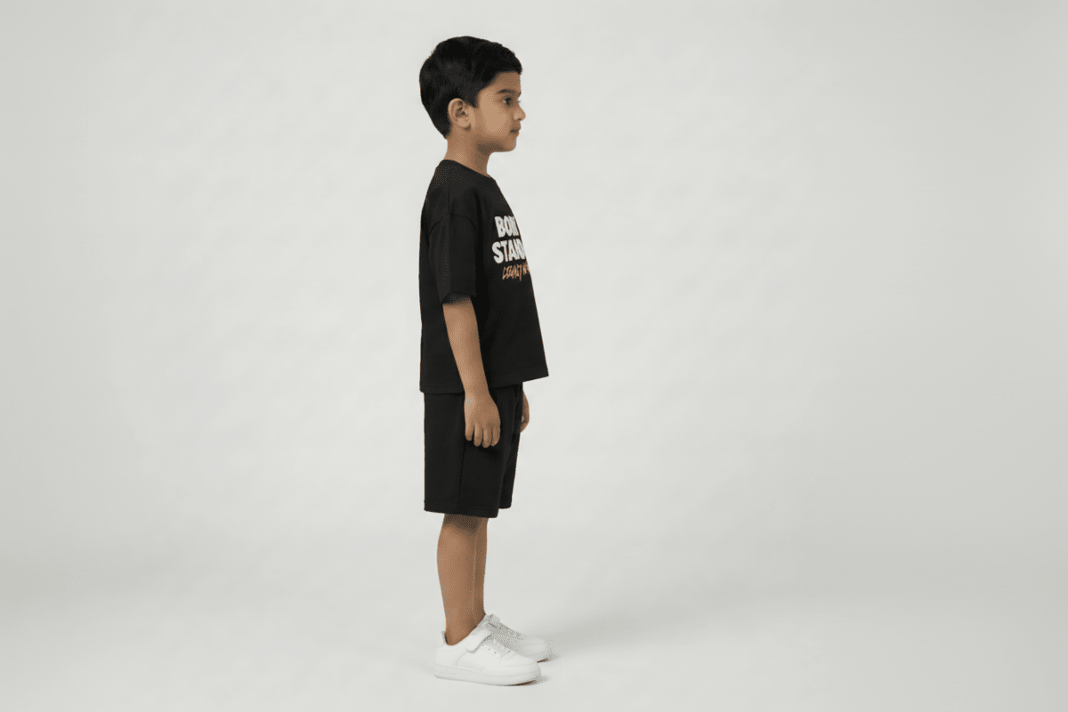 Child wearing a black t-shirt and shorts with visible branding on a white background